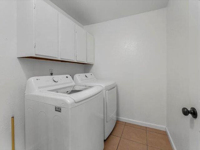 926 Cortina Dr, Orland, CA 95963 - clothes washing area featuring light tile patterned flooring, cabinet space, washing machine and dryer, and baseboards