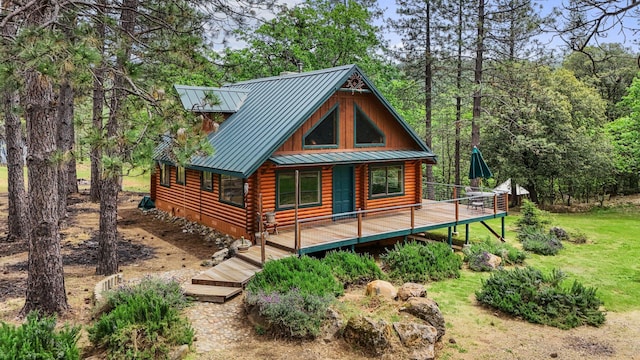 rear view of house featuring a standing seam roof, log siding, metal roof, and a wooden deck