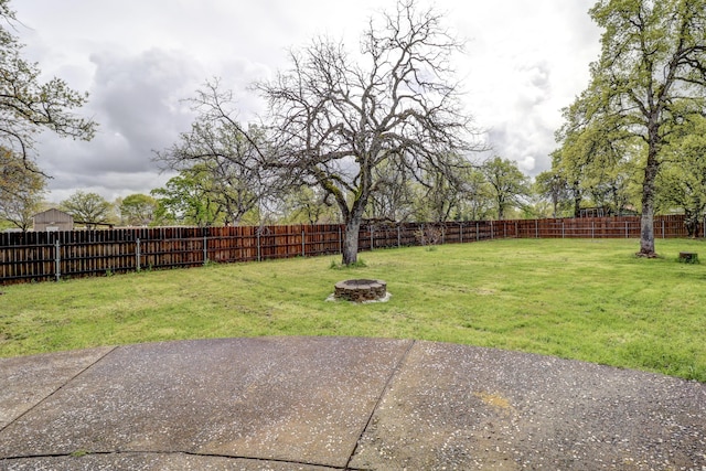 view of yard with a fenced backyard and a fire pit