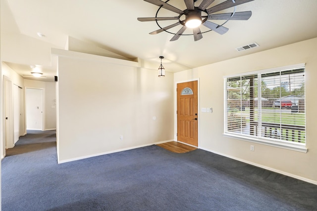 foyer entrance with dark carpet, ceiling fan, visible vents, and vaulted ceiling