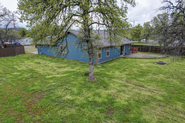 view of yard featuring fence, a fire pit, and a patio area