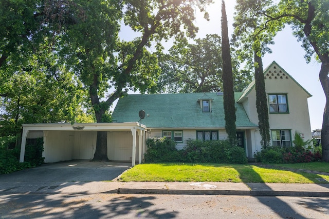 view of front of home with aphalt driveway, a front lawn, and an attached carport