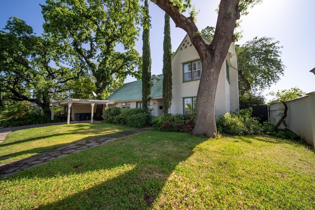 view of home's exterior featuring a yard, stucco siding, and fence