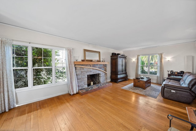 living room featuring a fireplace, baseboards, and wood-type flooring