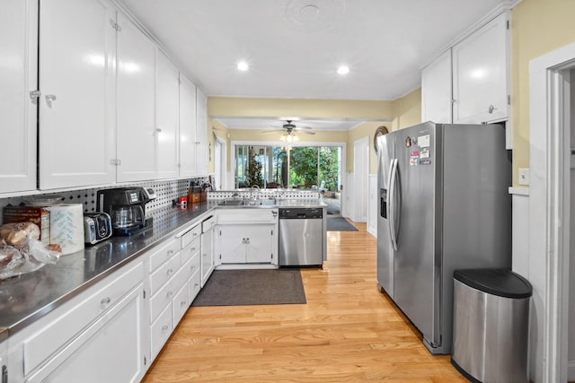 kitchen with recessed lighting, a sink, light wood-type flooring, white cabinetry, and appliances with stainless steel finishes