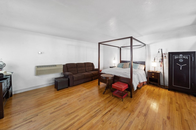 bedroom featuring light wood-style flooring and a wall mounted AC