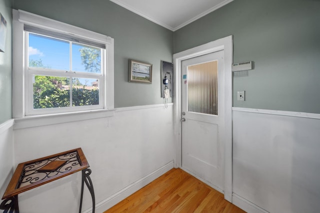 entryway featuring light wood-style floors and crown molding