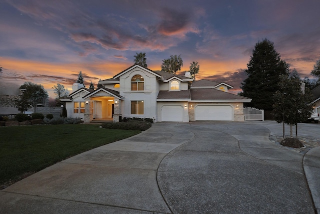 traditional home with concrete driveway, stone siding, stucco siding, a tile roof, and an attached garage