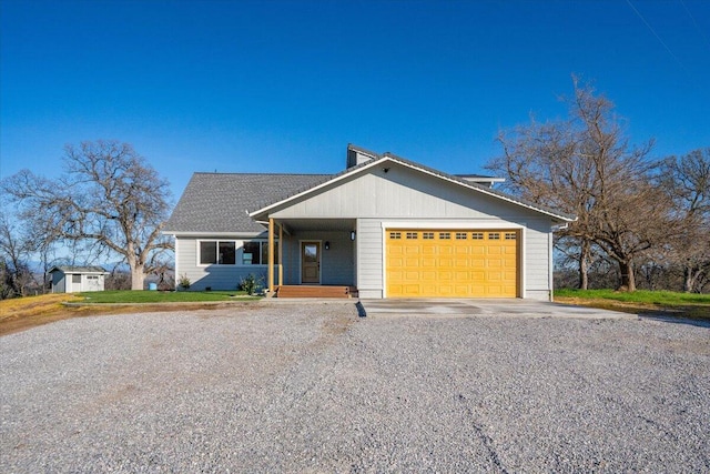 view of front of home featuring an attached garage and gravel driveway