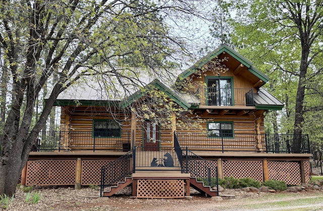back of property featuring a porch, log exterior, and stairs