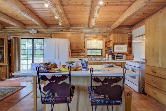 kitchen with a wealth of natural light, white appliances, open shelves, and track lighting