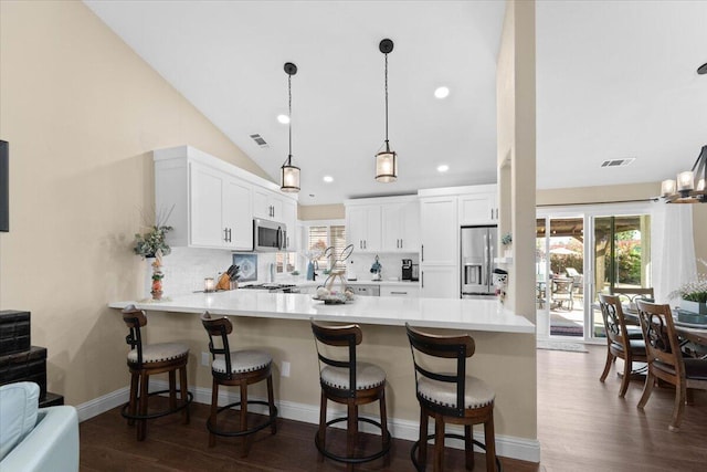 2919 Buckingham Dr, Shasta Lake, CA 96019 - kitchen with a breakfast bar area, dark wood finished floors, a peninsula, and stainless steel appliances