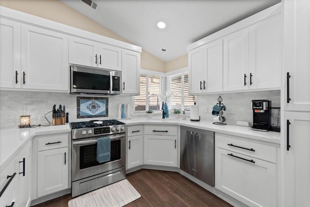 2919 Buckingham Dr, Shasta Lake, CA 96019 - kitchen with white cabinetry, decorative backsplash, appliances with stainless steel finishes, and vaulted ceiling