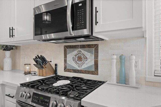 2919 Buckingham Dr, Shasta Lake, CA 96019 - kitchen with backsplash, light countertops, white cabinetry, and stainless steel appliances