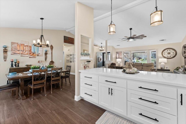 2919 Buckingham Dr, Shasta Lake, CA 96019 - kitchen with ceiling fan with notable chandelier, vaulted ceiling, light countertops, open floor plan, and dark wood-style floors