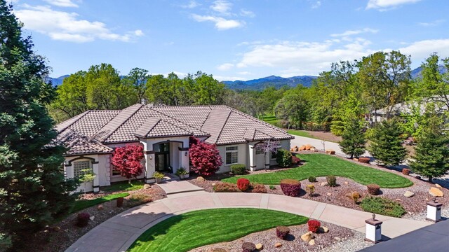 13194 Tierra Heights Rd, Redding, CA 96003 - view of front of property with a front yard, stucco siding, a tiled roof, and a mountain view