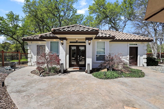 13194 Tierra Heights Rd, Redding, CA 96003 - view of front facade with a tiled roof, french doors, fence, and stucco siding