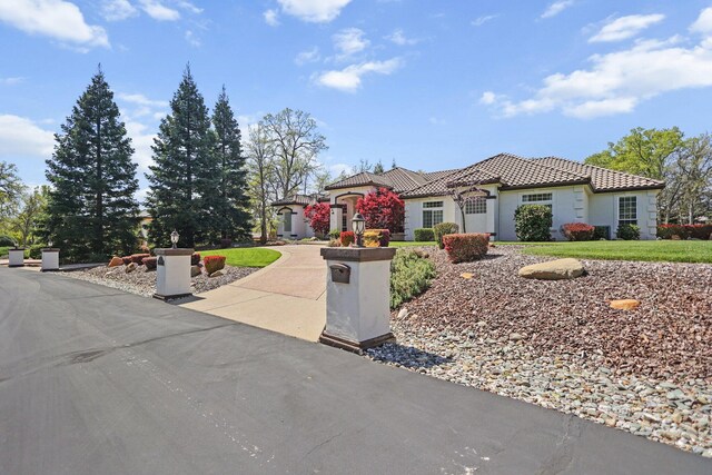 13194 Tierra Heights Rd, Redding, CA 96003 - mediterranean / spanish-style house with a tile roof, driveway, and stucco siding