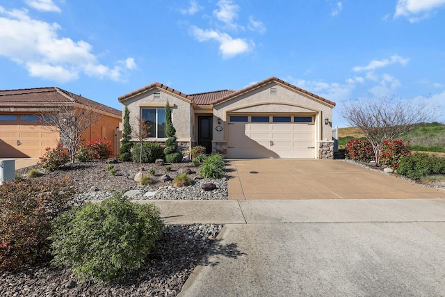 6180 Lucca Trl, Redding, CA 96003 - mediterranean / spanish-style home featuring concrete driveway, stucco siding, stone siding, and an attached garage
