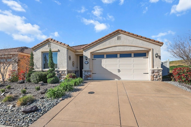 6180 Lucca Trl, Redding, CA 96003 - mediterranean / spanish house featuring an attached garage, driveway, stone siding, and a tile roof