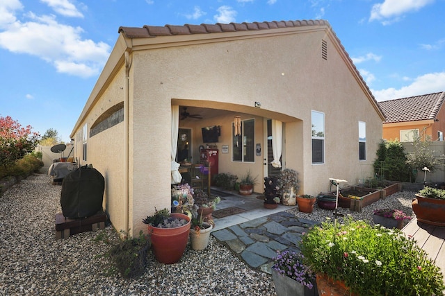 6180 Lucca Trl, Redding, CA 96003 - back of house featuring a tile roof, a vegetable garden, fence, and stucco siding