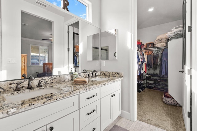 6180 Lucca Trl, Redding, CA 96003 - bathroom featuring a spacious closet, double vanity, visible vents, and a sink