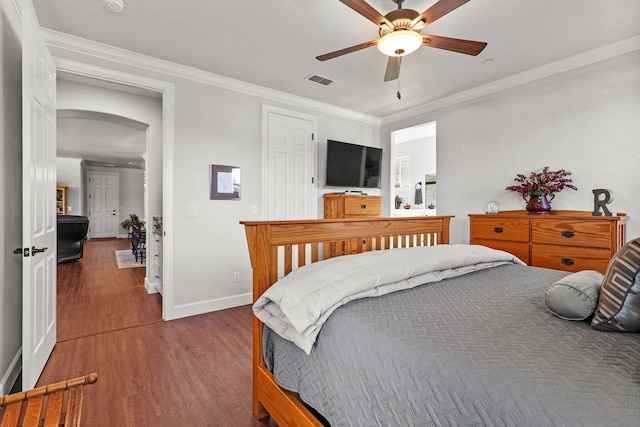 6180 Lucca Trl, Redding, CA 96003 - bedroom with baseboards, arched walkways, ornamental molding, ceiling fan, and dark wood finished floors