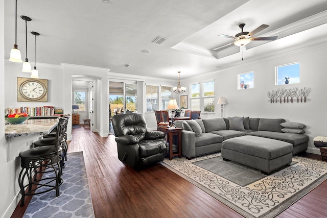 6180 Lucca Trl, Redding, CA 96003 - living room with ceiling fan with notable chandelier, arched walkways, ornamental molding, dark wood-style flooring, and baseboards