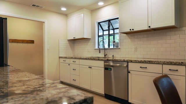 5080 Debbie Ln, Redding, CA 96002 - kitchen with stainless steel dishwasher, stone countertops, white cabinetry, a sink, and decorative backsplash
