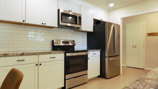 5080 Debbie Ln, Redding, CA 96002 - kitchen featuring stainless steel appliances, light wood-style floors, tasteful backsplash, light stone countertops, and recessed lighting