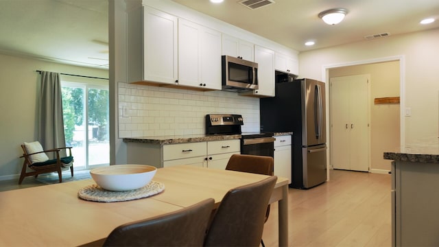 5080 Debbie Ln, Redding, CA 96002 - kitchen featuring stainless steel appliances, decorative backsplash, light wood-style flooring, white cabinets, and baseboards