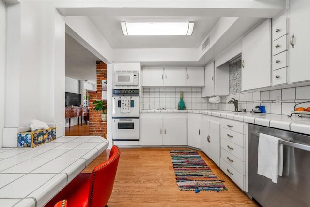 105 Kaer Ave, Red Bluff, CA 96080 - kitchen featuring tasteful backsplash, tile counters, white appliances, and white cabinets