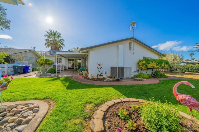 105 Kaer Ave, Red Bluff, CA 96080 - rear view of house featuring central AC unit, stucco siding, fence, and a lawn