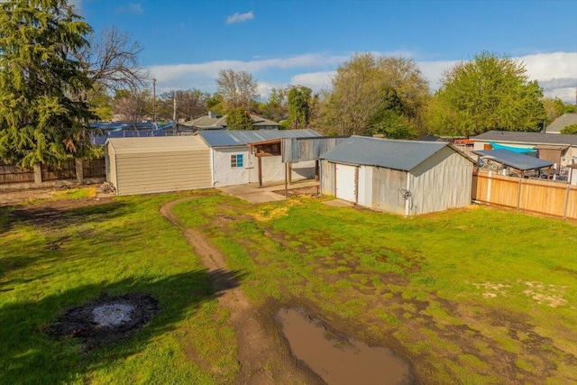 105 Kaer Ave, Red Bluff, CA 96080 - back of property featuring a lawn, an outbuilding, a fenced backyard, and a detached garage