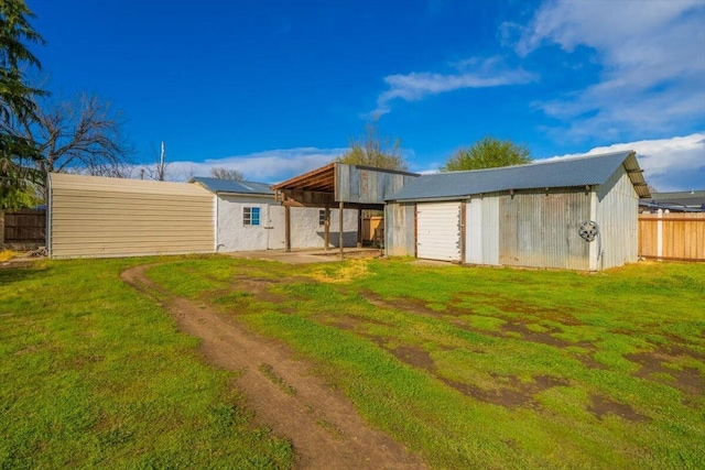 105 Kaer Ave, Red Bluff, CA 96080 - rear view of house featuring an outdoor structure, a lawn, a carport, a patio area, and fence
