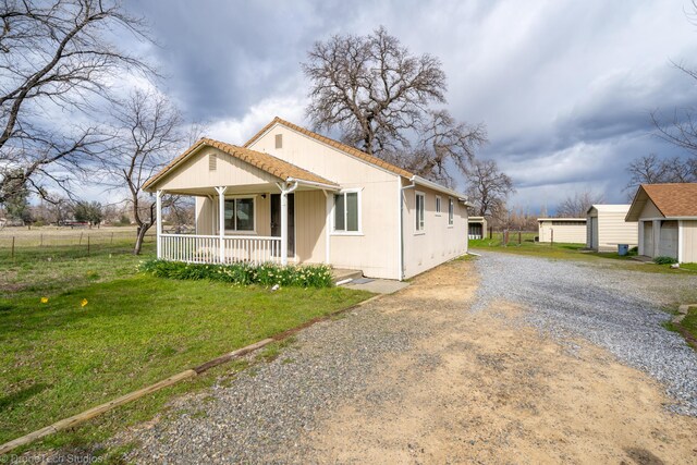 5995 Bellevue Ln, Anderson, CA 96007 - view of front of home featuring driveway, fence, a front lawn, and covered porch