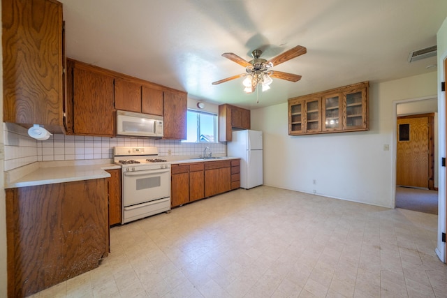 5995 Bellevue Ln, Anderson, CA 96007 - kitchen with a sink, light countertops, white appliances, brown cabinets, and decorative backsplash