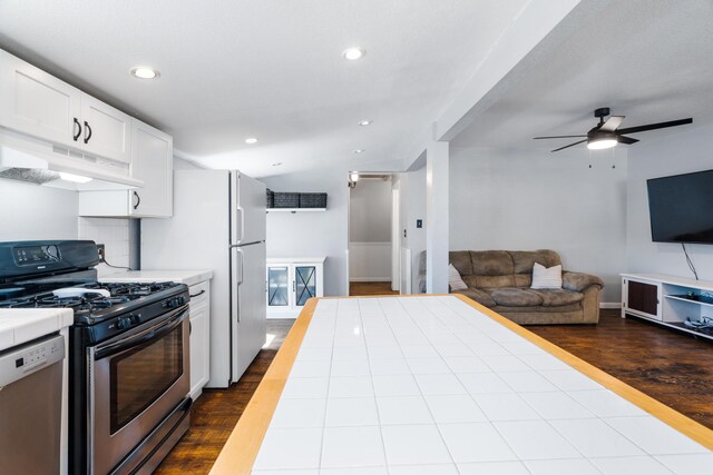 kitchen with under cabinet range hood, dark wood-style flooring, white cabinets, and stainless steel appliances
