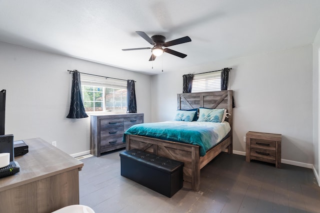 bedroom featuring baseboards, multiple windows, and hardwood / wood-style floors