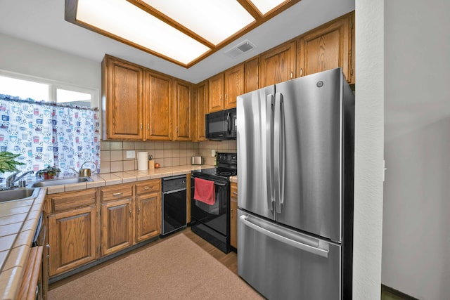 249 Ridgetop Dr Apt 239, Redding, CA 96003 - kitchen featuring black appliances, tile countertops, and brown cabinetry