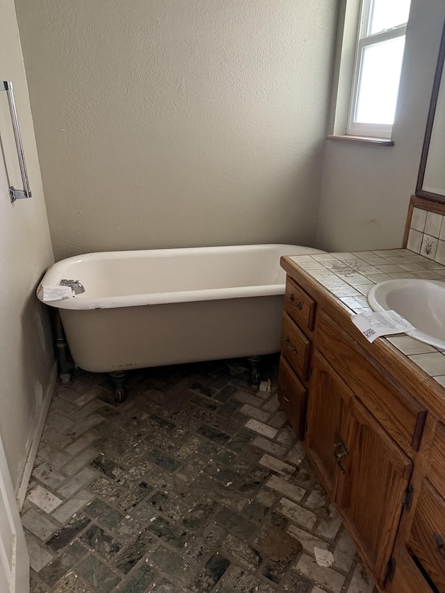 bathroom with a freestanding tub and vanity