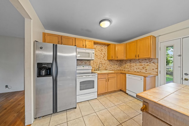 3082 Lawrence Rd, Redding, CA 96002 - kitchen featuring a sink, light tile patterned floors, tasteful backsplash, and white appliances