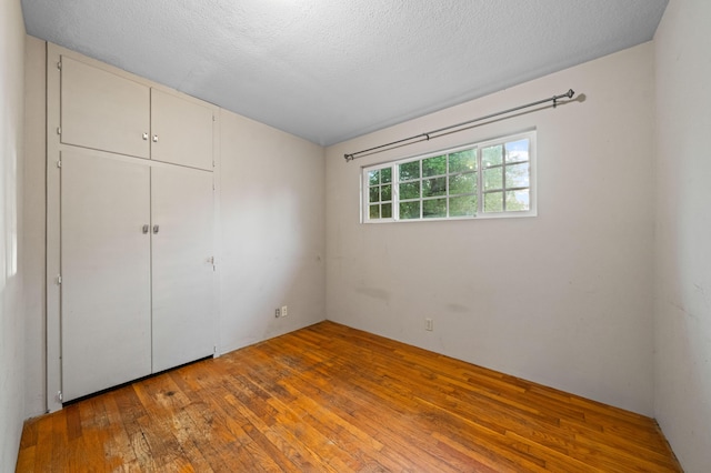 3082 Lawrence Rd, Redding, CA 96002 - unfurnished bedroom featuring a textured ceiling, a closet, and wood-type flooring