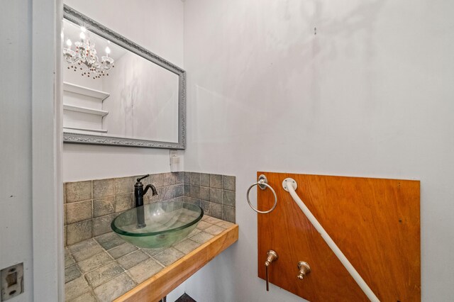 3082 Lawrence Rd, Redding, CA 96002 - bathroom with a notable chandelier, a sink, and decorative backsplash