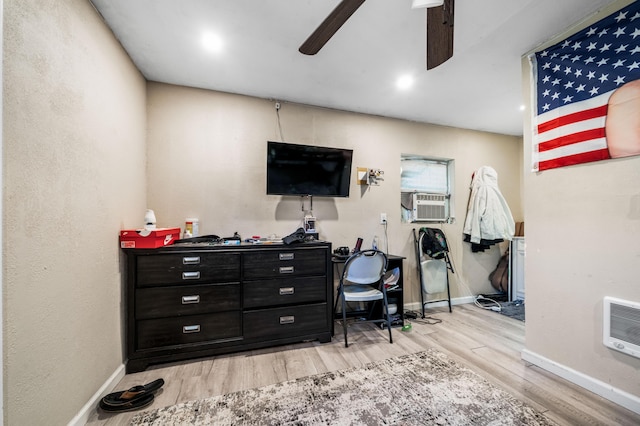 office area featuring ceiling fan, light wood finished floors, baseboards, and cooling unit