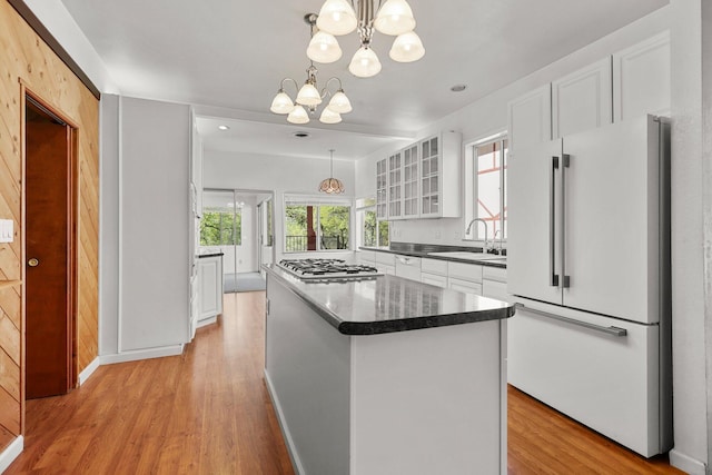 16588 Stanislaus Dr, Redding, CA 96001 - kitchen featuring white cabinets, a notable chandelier, a sink, freestanding refrigerator, and stainless steel gas cooktop