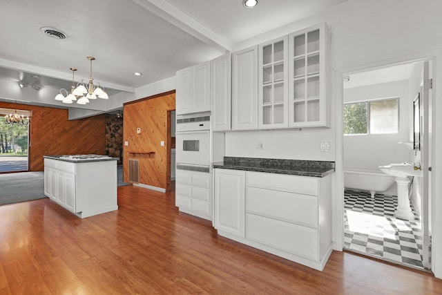 16588 Stanislaus Dr, Redding, CA 96001 - kitchen featuring glass insert cabinets, white oven, visible vents, a chandelier, and wood finished floors