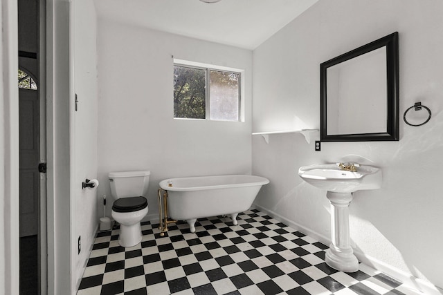16588 Stanislaus Dr, Redding, CA 96001 - bathroom featuring toilet, tile patterned floors, a freestanding tub, and baseboards