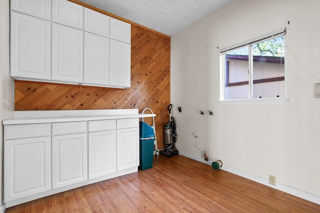 16588 Stanislaus Dr, Redding, CA 96001 - laundry room with light wood-type flooring, wooden walls, baseboards, and a textured ceiling