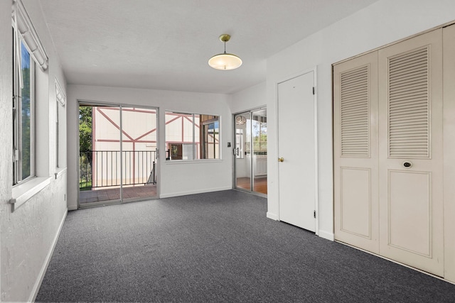 16588 Stanislaus Dr, Redding, CA 96001 - unfurnished room featuring a textured wall, plenty of natural light, baseboards, and dark carpet